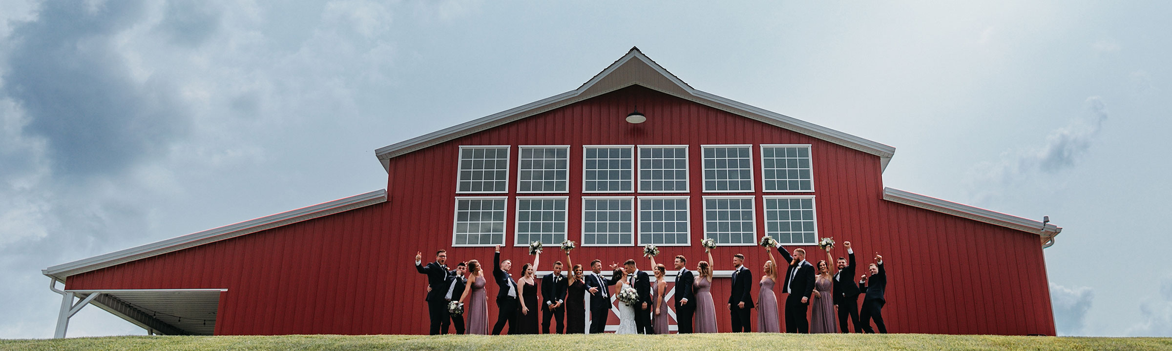 Wedding party cheering at the back of the barn